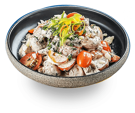A bowl of creamy chicken pasta with cherry tomatoes and fresh herbs